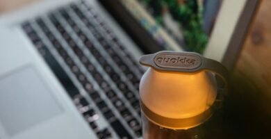 clear glass bottle beside macbook pro